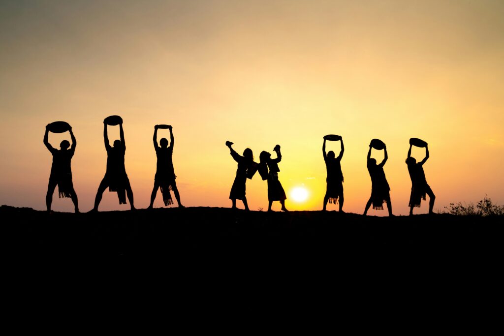 Silhouetted figures dancing vibrantly against a golden sunset, capturing the joy of a live performance.